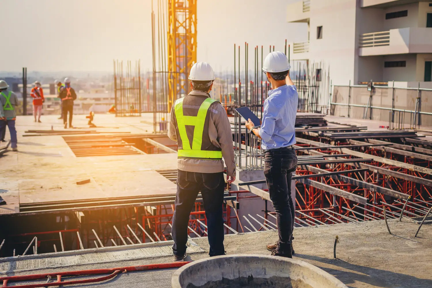 Bauingenieur und Vorarbeiter mit Touchpad besprechen und planen Arbeiten für die Baustelle im Freien.